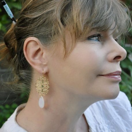 boucles d'oreilles Moscou mises en valeur sur modèle, longues avec une perle goutte en verre opaline sur une rosace baroque dorée tres fine