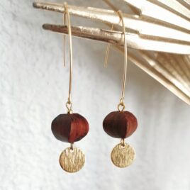Boucles d'oreilles sur un long crochet doré où une perle en bois de forme lampion japonais pend, en dessous un petit rond plat, texturé et doré est suspendu. environ 6cm de hauteur